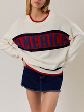 Load image into Gallery viewer, Oversized ivory knit America sweater with red and navy stripe graphic lettering, paired with denim mini skirt - 1