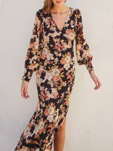 Load image into Gallery viewer, Black floral long sleeve midi dress with V-neck, flowing silhouette, and pink cream blooms, paired with tan heeled sanda - 4