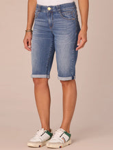 Load image into Gallery viewer, Women's medium blue artisanal denim Bermuda shorts with rolled cuffs and gold button, paired with white sneakers - 2