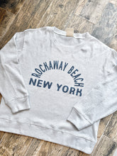 Load image into Gallery viewer, Grey thermal crew sweatshirt with Rockaway Beach New York graphic print, laid flat on wood surface - 1