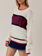 Load image into Gallery viewer, Oversized ivory knit America sweater with red and navy stripe graphic lettering, paired with denim mini skirt - 4