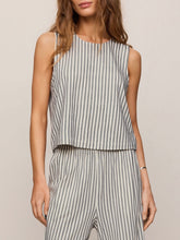 Load image into Gallery viewer, Woman wearing Sloane Knit Striped Top in Eclipse with matching striped pants, seated on olive chair - 3
