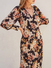 Load image into Gallery viewer, Black floral long sleeve midi dress with V-neck, flowing silhouette, and pink cream blooms, paired with tan heeled sanda - 5