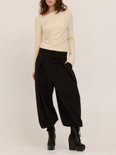 Load image into Gallery viewer, Harlow cream long sleeve top with asymmetric draped neckline and ruched waist, paired with black wide-leg trousers - 7
