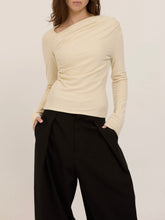 Load image into Gallery viewer, Harlow cream long sleeve top with asymmetric draped neckline and ruched waist, paired with black wide-leg trousers - 1
