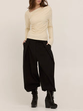 Load image into Gallery viewer, Harlow cream long sleeve top with asymmetric draped neckline and ruched waist, paired with black wide-leg trousers - 6

