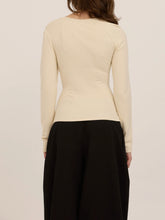 Load image into Gallery viewer, Harlow cream long sleeve top with asymmetric draped neckline and ruched waist, paired with black wide-leg trousers - 3

