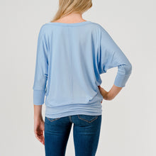Load image into Gallery viewer, Light blue dolman sleeve boat neck top with relaxed fit, paired with blue jeans on female model - 5
