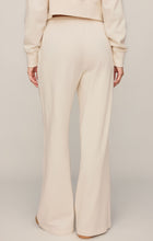 Load image into Gallery viewer, Woman wearing cream wide-leg drawstring lounge pants with matching sweatshirt and tan suede sneakers - 5
