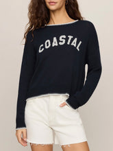 Load image into Gallery viewer, Woman wearing navy blue Coastal Sienna Sweater in Eclipse with white letter graphic and cream denim shorts - 1

