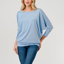 Load image into Gallery viewer, Light blue dolman sleeve boat neck top with relaxed fit, paired with blue jeans on female model - 1
