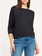 Load image into Gallery viewer, Black dolman boat neck top with 3/4 sleeves and relaxed fit, paired with blue jeans - 5

