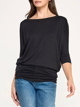 Load image into Gallery viewer, Black dolman boat neck top with 3/4 sleeves and relaxed fit, paired with blue jeans - 1
