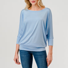 Load image into Gallery viewer, Light blue dolman sleeve boat neck top with relaxed fit, paired with blue jeans on female model - 2
