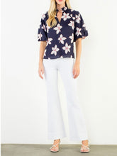 Load image into Gallery viewer, Navy floral puff sleeve top with white and red flower print, V-neck, paired with white pants - 2

