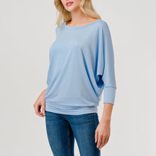 Load image into Gallery viewer, Light blue dolman sleeve boat neck top with relaxed fit, paired with blue jeans on female model - 3
