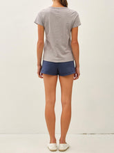 Load image into Gallery viewer, Woman wearing a light gray cotton slub crew neck tee with short sleeves, paired with navy athletic shorts. - 4
