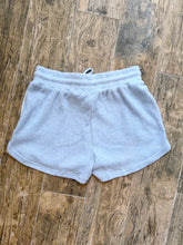 Load image into Gallery viewer, Light blue waffle knit thermal shorts with drawstring waistband and side pockets laid flat on wood surface - 3
