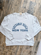 Load image into Gallery viewer, Grey thermal crew sweatshirt with Rockaway Beach New York graphic print, laid flat on wood surface - 2
