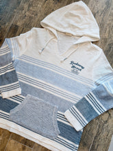 Load image into Gallery viewer, Rockaway Beach Stay Salty ombre blue striped baja hoodie with kangaroo pocket and hood on wood floor - 1
