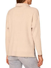Load image into Gallery viewer, Woman wearing a cream cable knit cowl neck sweater with drawstring detail and long sleeves paired with jeans - 2
