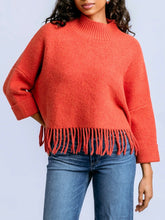 Load image into Gallery viewer, Sachi tangerine fringe sweater with mock neck, 3/4 sleeves, and boho fringe hem styled with blue jeans - 3
