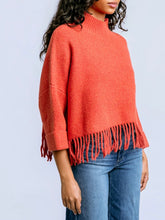 Load image into Gallery viewer, Sachi tangerine fringe sweater with mock neck, 3/4 sleeves, and boho fringe hem styled with blue jeans - 4
