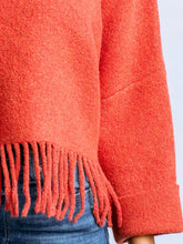 Load image into Gallery viewer, Sachi tangerine fringe sweater with mock neck, 3/4 sleeves, and boho fringe hem styled with blue jeans - 2
