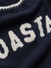 Load image into Gallery viewer, Woman wearing navy blue Coastal Sienna Sweater in Eclipse with white letter graphic and cream denim shorts - 5
