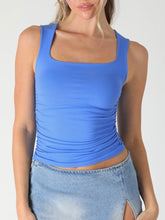 Load image into Gallery viewer, Woman wearing blue square neck shirred tank top with ruched sides paired with light wash denim skirt - 1
