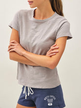 Load image into Gallery viewer, Woman wearing a light gray cotton slub crew neck tee with short sleeves, paired with navy athletic shorts. - 1
